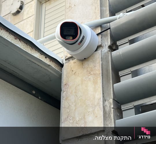 מצלמת אבטחה מותקנת על קיר חיצוני של בניין